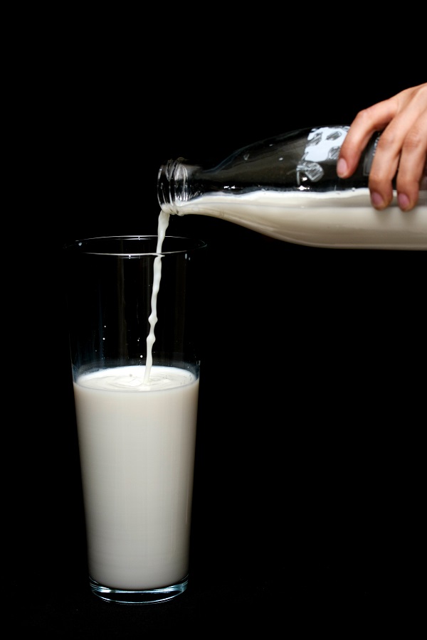 person pouring milk in highball glass 1435706