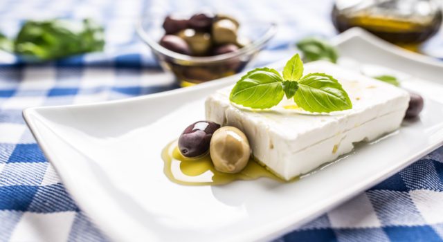 Ελληνικό τυρί φέτα με ελαιόλαδο ελιές και φύλλα βασιλικού.