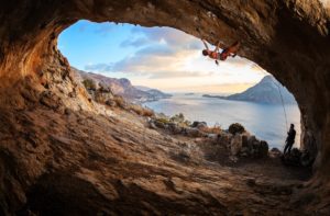 Young,Woman,Lead,Climbing,In,Cave,With,Beautiful,View,In